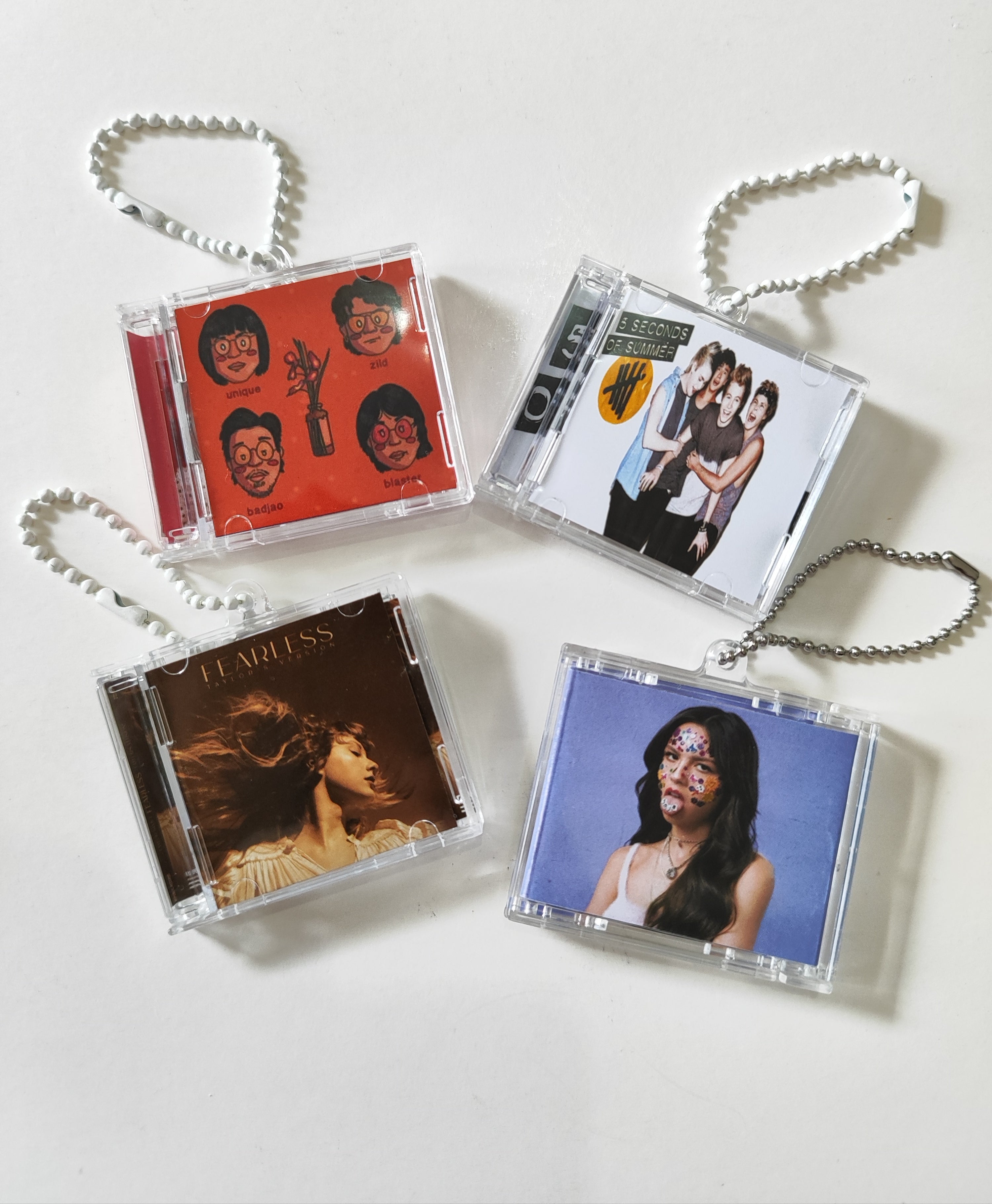 Four compact discs with colorful covers on a white background